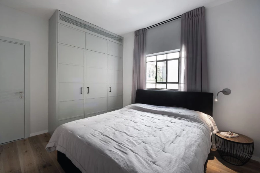 בחדר השינה של בני הזוג הוגדל מפתח החלון באופן שיכניס יותר אור טבעי ואוויר לחדר ויתרום בכך לתחושה המאווררת והרחבה