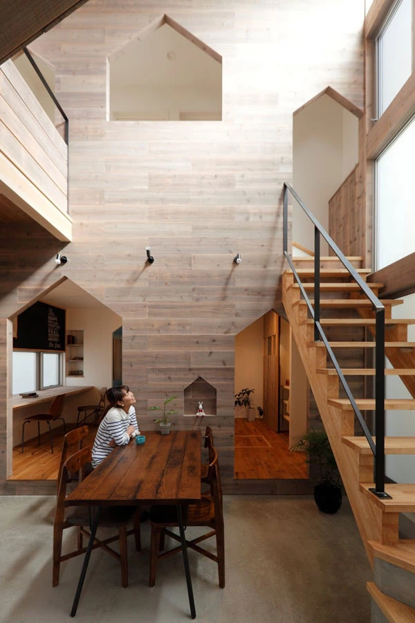 מדרגות רחבות מעץ מחברות בין קומת הקרקע של הבית לבין הקומה העליונה