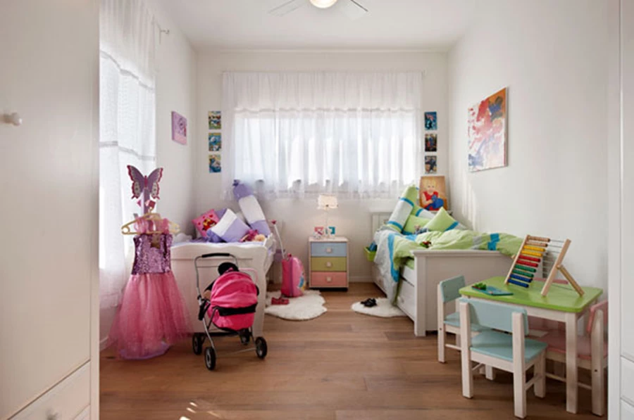 חדר הילדים: פרטי ריהוט מעץ לבן, וילונות קלילים, וגווני פסטל רכים המשתלבים באביזרים משלימים.
