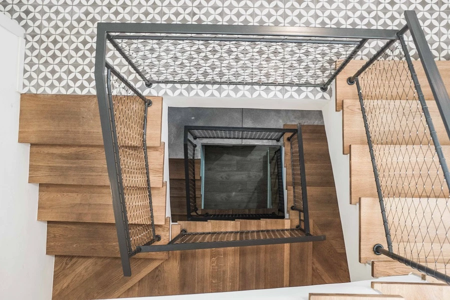 גרם מדרגות בחלל בית פרטי בהרצליה בעל 4 קומות. מעקה משולב רשת נירוסטה אקסטנדד. צילום גלעד ראדאט 