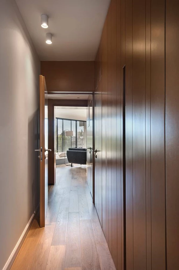 כניסה מהאלמנט המרכזי למבואת החדרים, בה אף דלתות החללים, חדר העבודה, התקרות והארונות עשויים מ-MDF תוך יצירת המשכיות חומרית-ויזואלית.