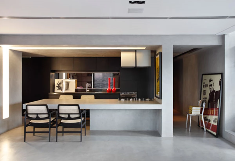 המטבח: עיצוב מאופק בהשוואה לצבעוניות הכללית. במרכזו ניצב שולחן עשוי משטחי בטון הממסגרים את החלל בקווים ארכיטקטוניים.
