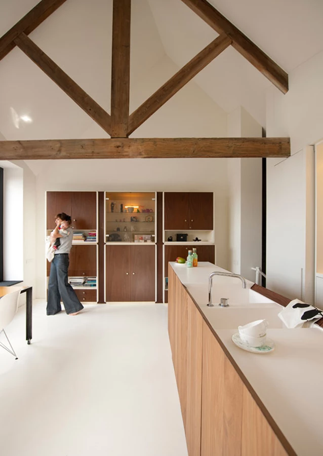 המטבח הממוקם בקומת הגג תחת מסבך קורות העץ המקנה לחלל אווירה חמה של בקתת עץ ברוח מודרנית.