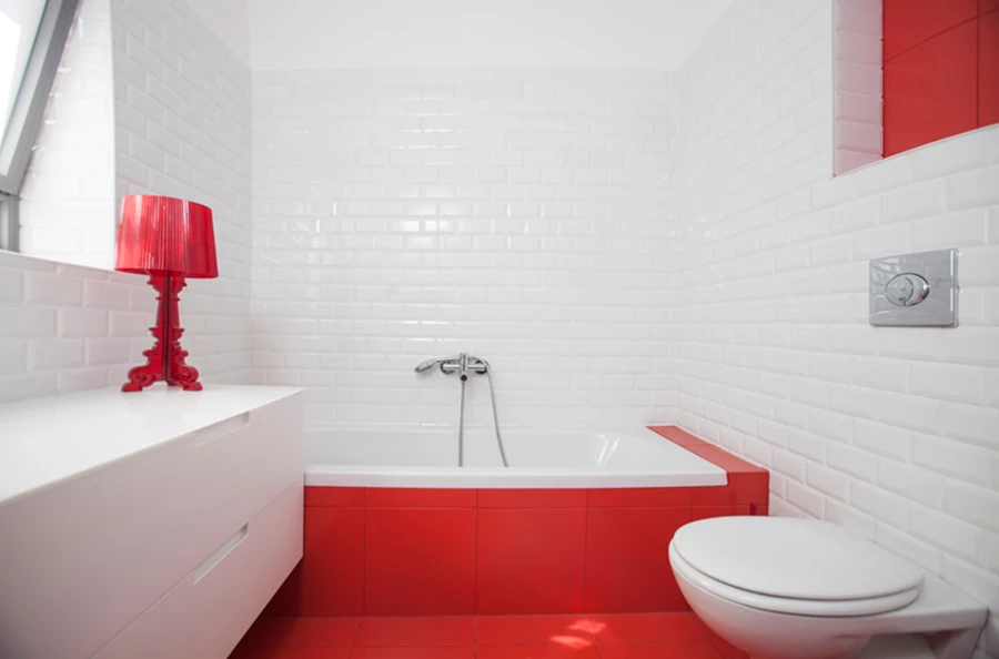 תעוזה אדומה בחדר הרחצה שבקומת הכניסה: ריצוף וחזית אמבט באדום עז.