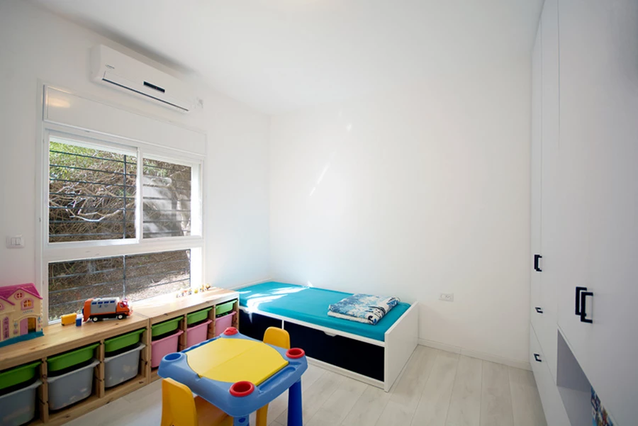  חדר הילדים. ארון הקיר משלב ארון בגדים עם מגירות לצעצועים ומדף לאחסון משחקים או ספרים.